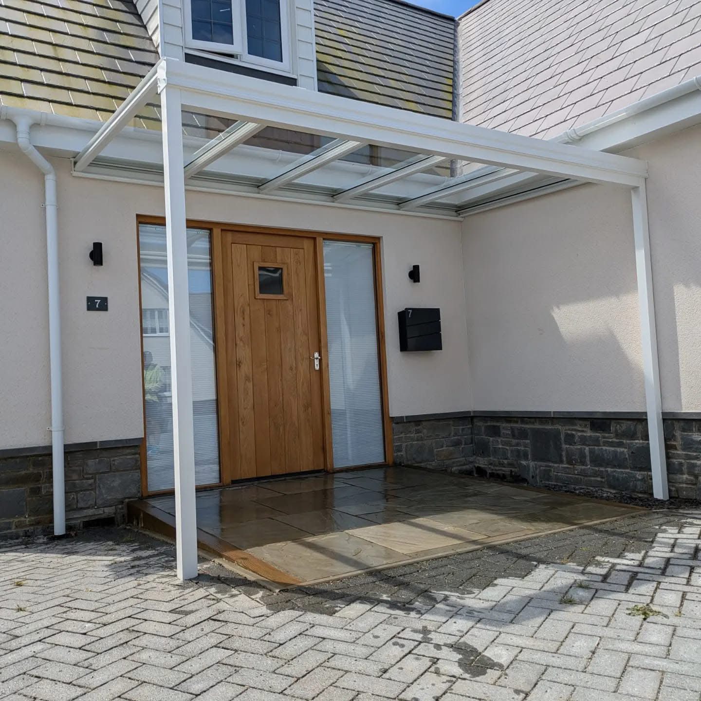 wall mounted aluminium canopy protecting outdoor seating area